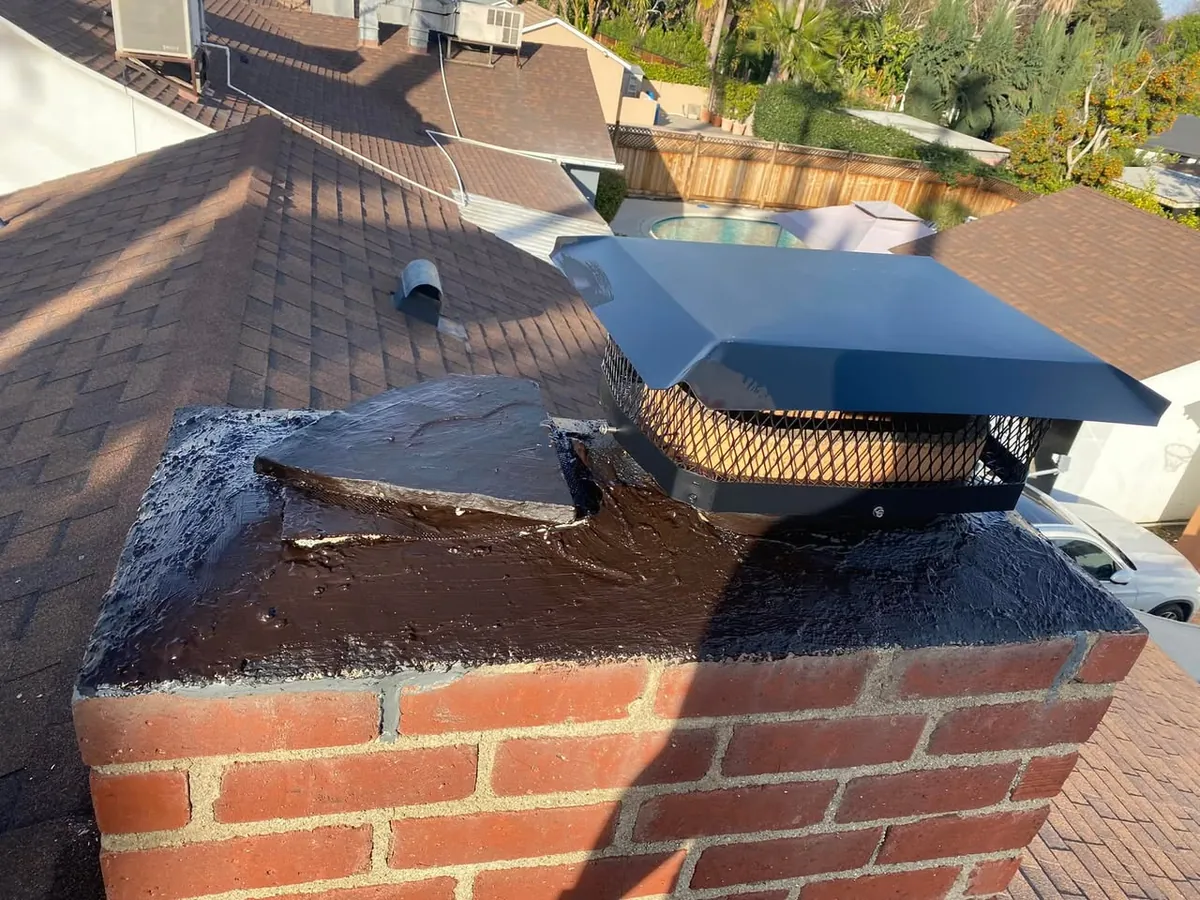 Brick chimney above a tile roof
